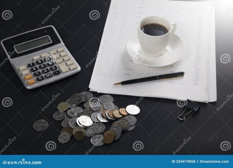 calculadora y monedas sobre una mesa